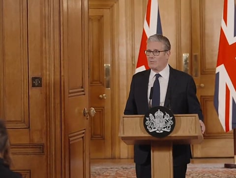 In the image Keir Starmer is shown speaking in a podium
