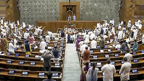 Indian parliament with all the members standing up and facing the speaker.