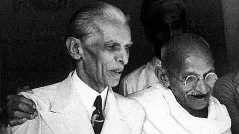 Muhammad Ali Jinnah and Mahatma Gandhi walking as friends with smiles on their faces.
