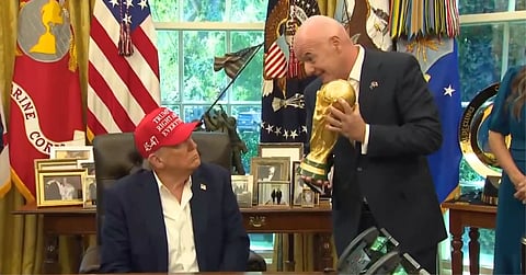 Trump is shown the world cup by Infantino.