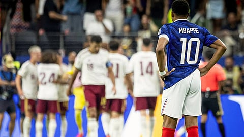 Kylian Mbappe standing watching Spain celebrate.