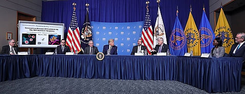 Image shows Trump and US health deparment on a discussion table the background is flags of US and health department.