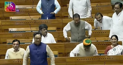Image from the parliament opposition making ruckus and protesting and showing placards when Kiren Rijju starts speaking.