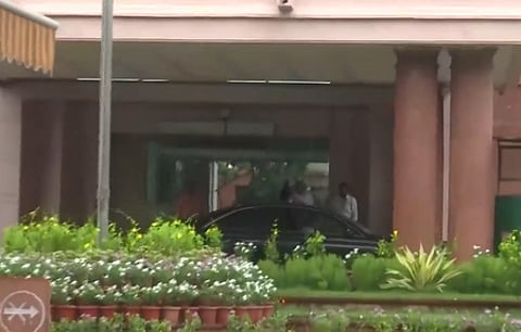 In the image a car is shown outside a government office