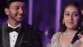 Image is a screenshot from the engagement of SIya Goyal and Ketan Agarwal. the couple are talking to someone and are dressed in a extravagant clothes.
