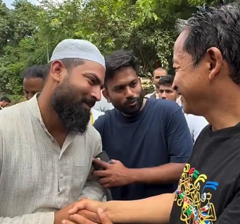 Image of Junaid Malik CJP food volunteer standing and shaking hands with Sonam Wangchuk. In the image Abhijeet Dipke is praising him as well.