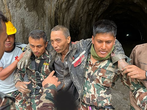 Image of man getting rescued after tragic Nepal flash floods.