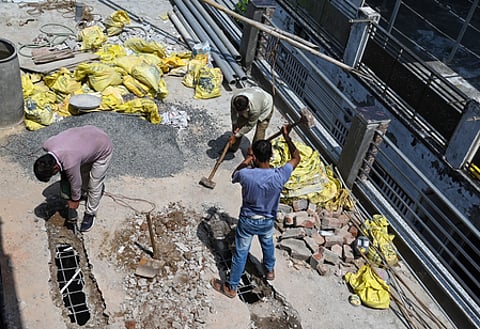 Labourers are shown demolishing building