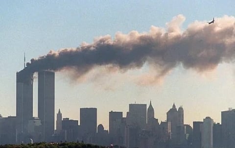 Image of 9/11 with the twin tower being attacked. in the image large plume of flame emerges from the building with another airplane seen at a distance.