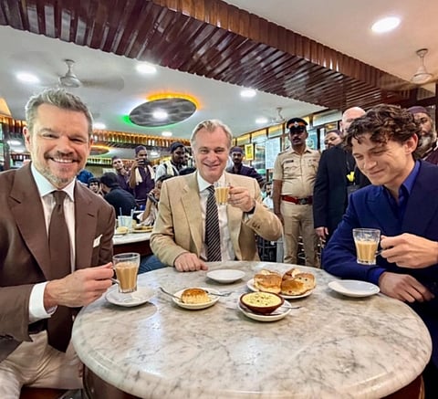 Image of Matt Damon (left), Christopher Nolan (center), Tom Holland (Right) drinking chai and eating muska bun at Mumbai's Olympia Coffee House whose license has been suspended recently.
