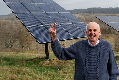 Image of Wendell Berry stands before the solar panels on his farm in Henry County