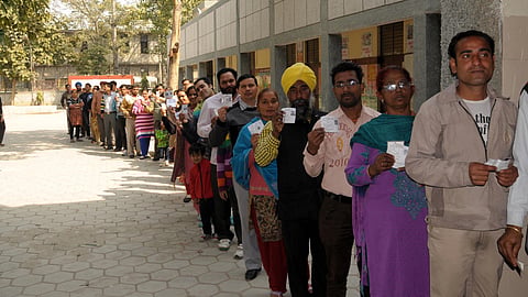 A group of individual standing in line for casting their vote.