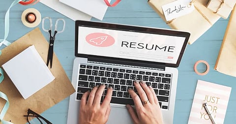 Student writing a resume on a laptop