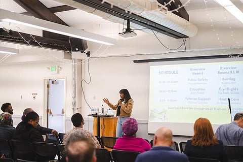 Andrea Bell, director of Oregon Housing and Community Services, speaking to a room full of people.