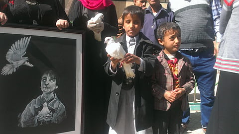 Two kids stand with a white pegion to protest against war.