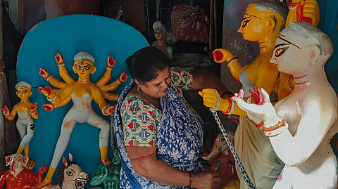 A woman painting a Durga Idol