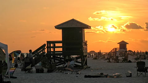 A sea beach with visitors surrounding the lifegaurd shops