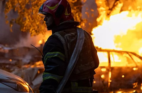 Image of a fireman standing the image is of Russian drone attack on Kyiv on the 4th July 2025.