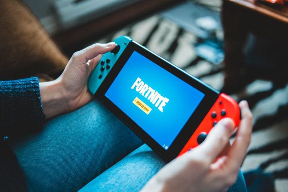 Gamer at his station playing the recent version of fortnite Image source: Photo by Alex Haney on Unsplash
