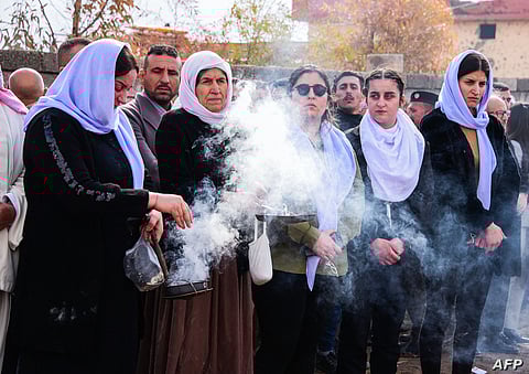 Mourners prepare to bury the remains of Yazidi victims in a cemetery in Sinjar, Iraq