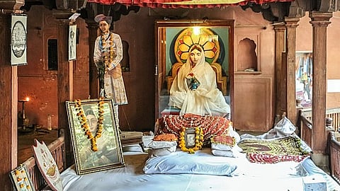 इस तस्वीर में अहिल्याबाई की फोटो है, जिस पर फूलों की माला चढ़ी हुई है, और दिखाई दे रहा है कि लोग उनकी तस्वीर पर पूजा करते हैं।