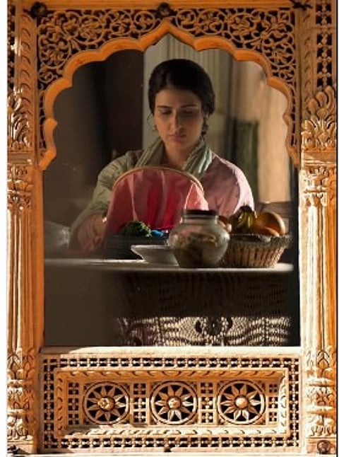 शीशे के सामने खड़ी एक महिला