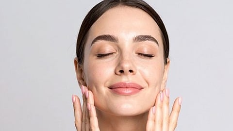 एक महिला अपने चेहरे पर हाथ रखे, आश्चर्य या चिंतन व्यक्त कर रही है