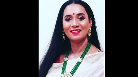 एक मुस्कुराती हुई महिला जो खुशी और आत्मविश्वास से भरी दिख रही है।
