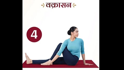 एक महिला वक्रासन योग करते हुए नजर आ रही है।