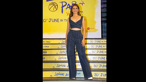 एक लड़की स्टाइलिश अंदाज़ में पोज़ करते हुए खड़ी है।