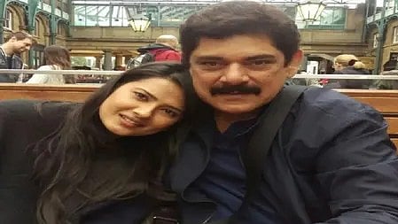 दो लोग प्यारी मुस्कान के साथ बैठे, खुशियों भरा पल साझा करते हुए|