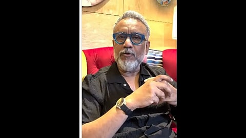 कुर्सी पर बैठे व्यक्ति का क्लोज़अप, कुछ बता रहे हैं|