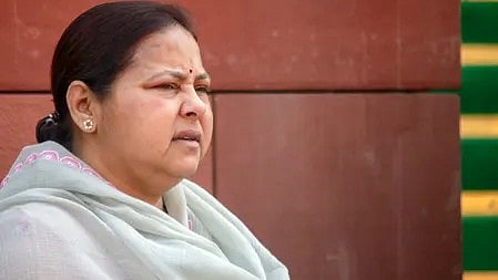 एक महिला बैठी हुई, ध्यान केंद्रित करती हुई या सामान्य स्थिति में।