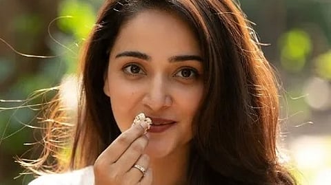 एक लड़की हाथ में मखाना लेकर हेल्दी स्नैक दिखा रही है।