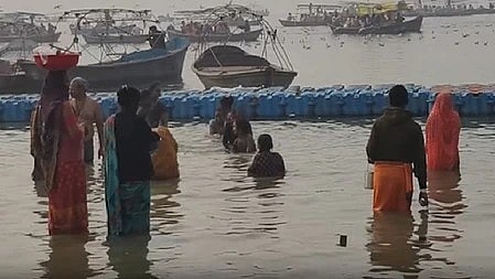 घाट पर मार्गशीर्ष अमावस्या के अवसर पर स्नान करते श्रद्धालु और भीड़ का दृश्य।