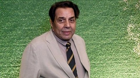 चित्र में अभिनेता धर्मेंद्र दिखाई दे रहे हैं, कैमरे की ओर शांत भाव से देखते हुए।