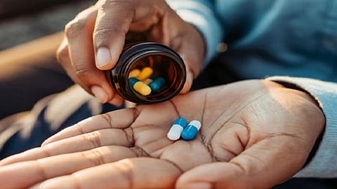 हाथ में कुछ गोलियां और टैबलेट्स, दवा लेने का संकेत|