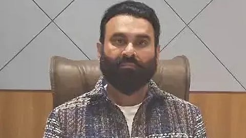 एक आदमी बैठा हुआ नजर आ रहा है।