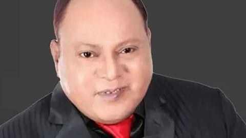 मर्द तांगे वाला गायक माइक्रोफोन पकड़े मंच पर गाते हुए|