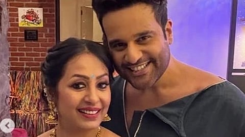 कृष्णा और उनकी साथी की मुस्कुराती हुई फोटो।