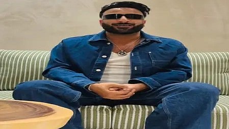 शहबाज बदेशा बैठे हुए, सोचते हुए और कैमरे की ओर देख रहे हैं|