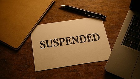 सस्पेंड नोट और पेन रखे हुए, निलंबन का संकेत|