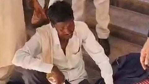 गुना, मध्य प्रदेश में कलेक्ट्रेट परिसर में जमीन के विवाद से परेशान किसान नीचे बैठा नजर आ रहा है|