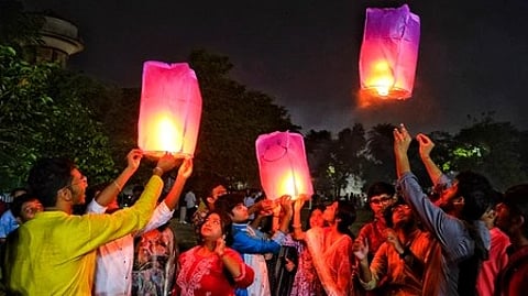 कुछ लोग आसमान में रंगीन हॉट एयर बैलून नजर आ रहे हैं।