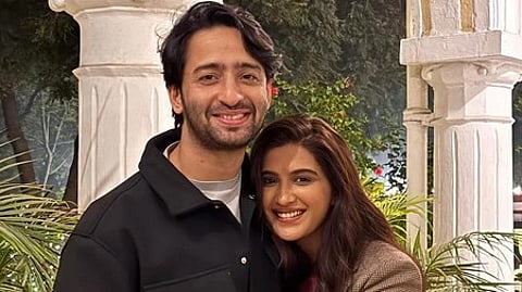 अभिनेता और एक अभिनेत्री का साथ खड़े होकर पोज देते हुए दृश्य|