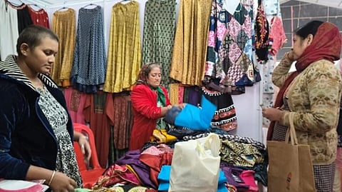 सरस मेले में फूल और अन्य सामान खरीदते लोग|