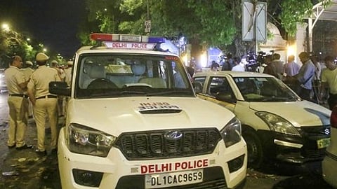 सड़क पर खड़ी दिल्ली पुलिस की गाड़ी|