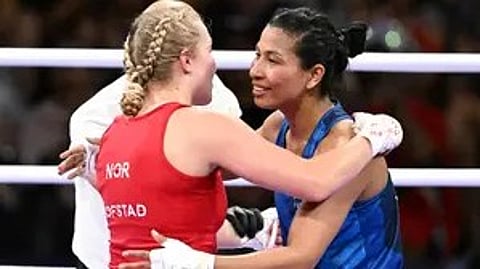 तस्वीर में दो लड़कियां बॉक्सिंग रिंग में खड़ी हैं, एक लाल और दूसरी नीला पहना है।