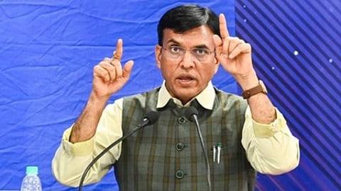 एक आदमी मंच पर बोलते हुए, जनता को संबोधित करते नजर आ रहा है।