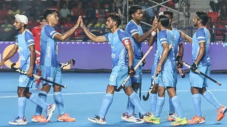 हॉकी स्टिक लिए हुए भारतीय खिलाड़ी खेल के लिए तैयार दिखाई दे रहे हैं।